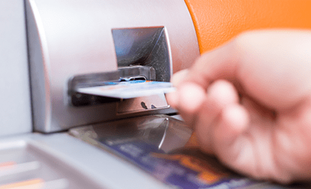 Person inserting a card into a machine.