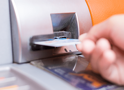 Person inserting a card into a machine.