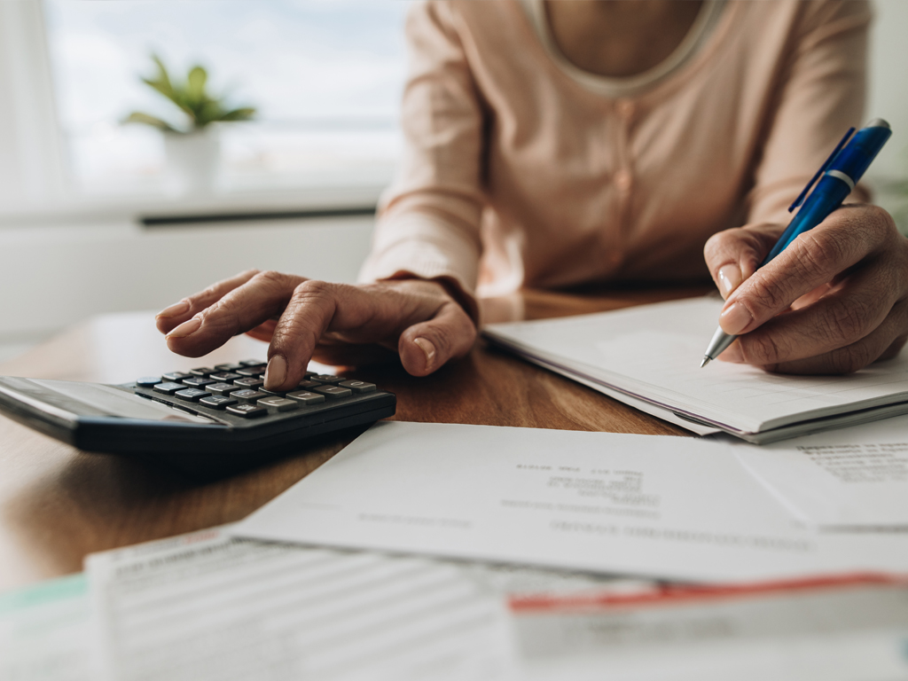 A woman writing and calculating a certificate of deposit.