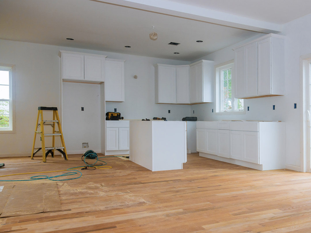 A bright white good sized unfinished kitchen.
