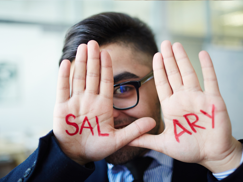 A man holding up both hands with the word "SALARY" on them.