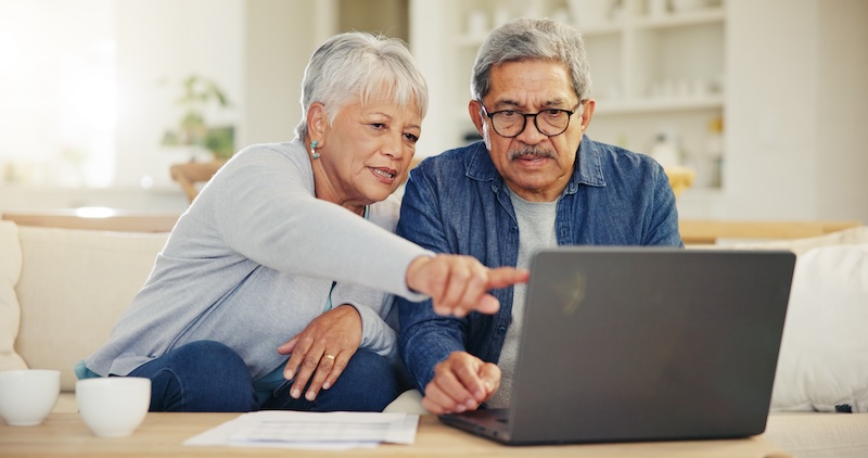Senior, pareja y la planificación en la computadora portátil en la sala de estar con el documento para las finanzas, la inversión o la jubilación. Anciano hombre, mujer y apuntando por la tecnología para la banca en línea, saldo de la cuenta o el ahorro.